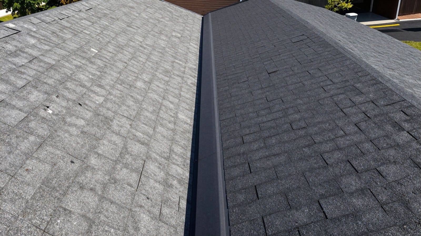 Close-up of asphalt shingles comparing faded texture on one side with restored texture on the other.